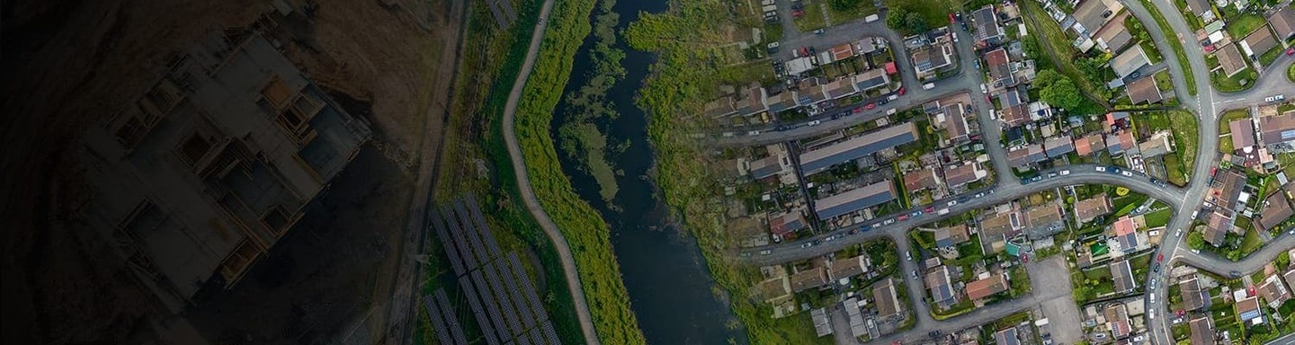 An aerial perspective showcasing a suburban neighborhood adjacent to a lush wetland area
